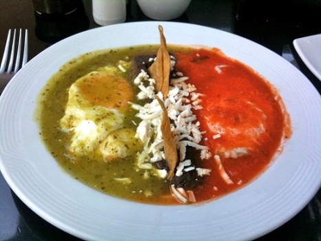 Huevos divorciados (Two eggs over fried tortilla with red and green salsa)