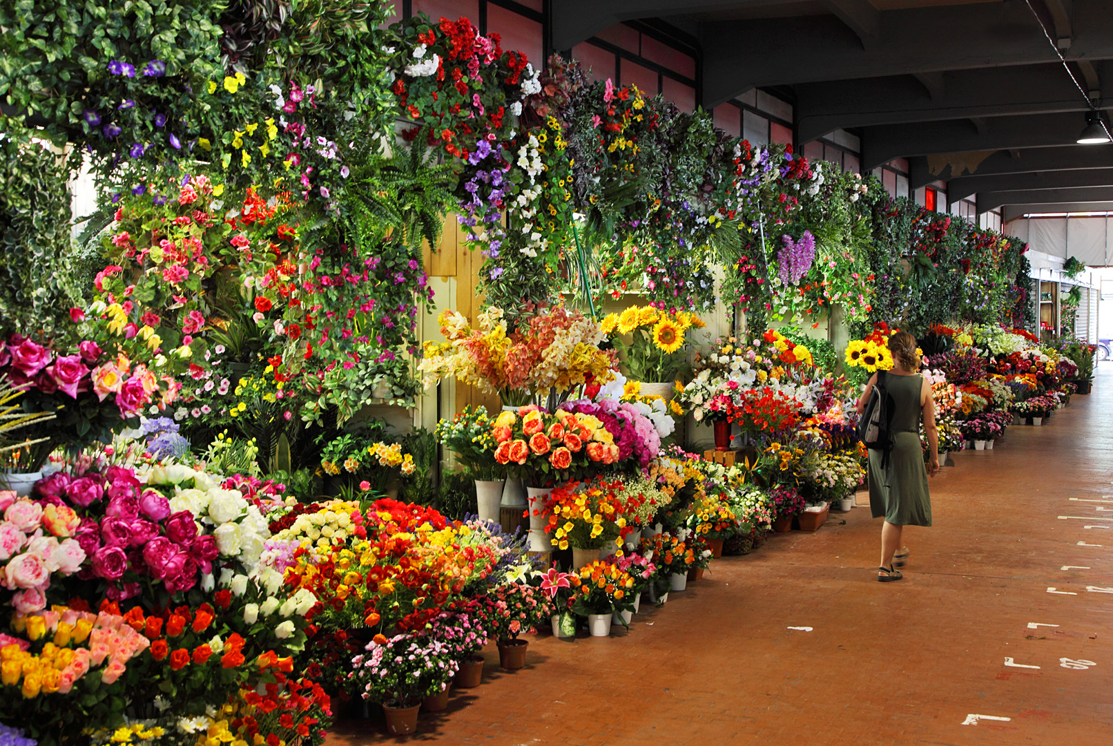 Exterior del mercado, totalmente lleno de distintos arrglos florales de diferentes tamaños y tipos de flores